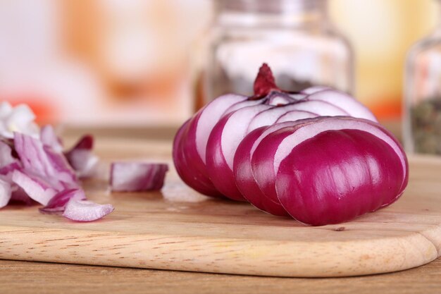 Foto corte a cebola na tábua na mesa de madeira no fundo brilhante