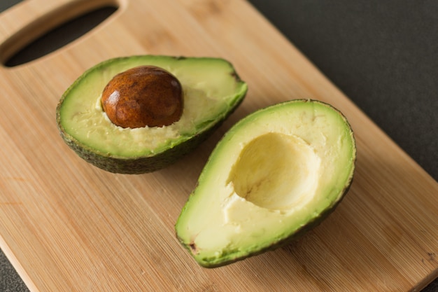 Corte el aguacate en una tabla de cortar de madera de roble.