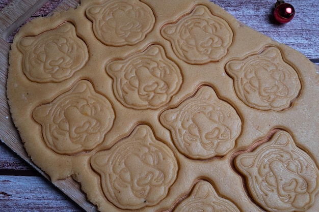 Corte biscoitos em forma de cabeça de tigre da massa para o ano novo fechar