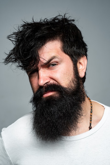 Corte de cabelo de homem, estilo de cabelo moderno. Feche o retrato do modelo masculino com cabelo comprido. Conceito de cuidados de saúde e cuidados com os cabelos. Hipster barbudo.