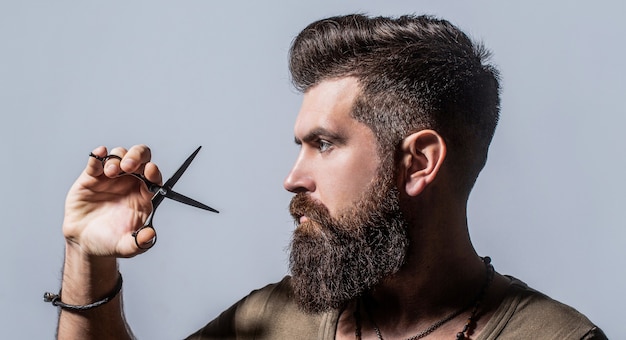 Corte de cabelo do homem na barbearia. Tesouras de barbeiro, barbearia. Tesouras de barbeiro.