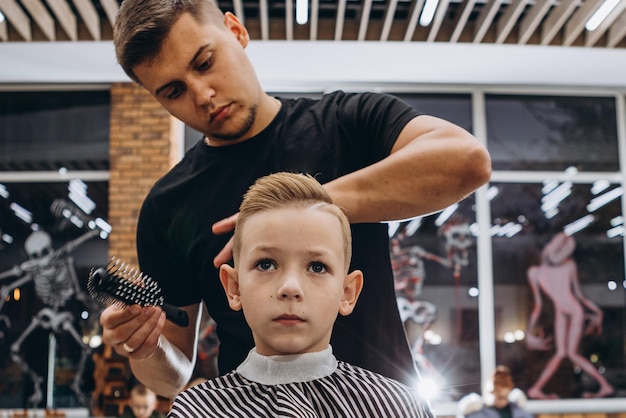 Corte de cabelo infantil e cabeleireiro apara garotinho barbearia é um cabeleireiro moderno