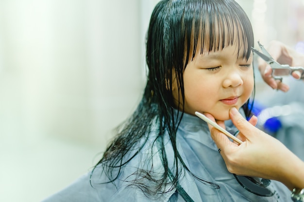 Corte de cabelo menina asiática. cabeleireiro, salão de beleza