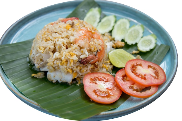 Foto corte de camarão e lula arroz frito com tomates e pepinos em fatias em folha de banana em branco isolado