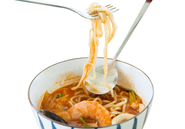 Corte de macarrão coreano em sopa de frutos do mar picante com carne de porco, camarão, lula e mexilhões em branco isolado.