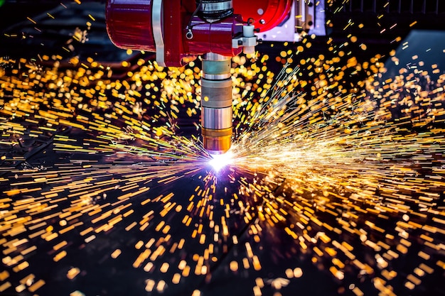 Corte de plasma a laser CNC de metal, tecnologia industrial moderna. Profundidade de campo pequena. Aviso - tiro autêntico em condições desafiadoras. Um pouco granulado e talvez borrado.