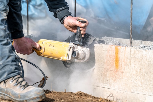 Corte de tijolos de concreto com um moedor elétrico