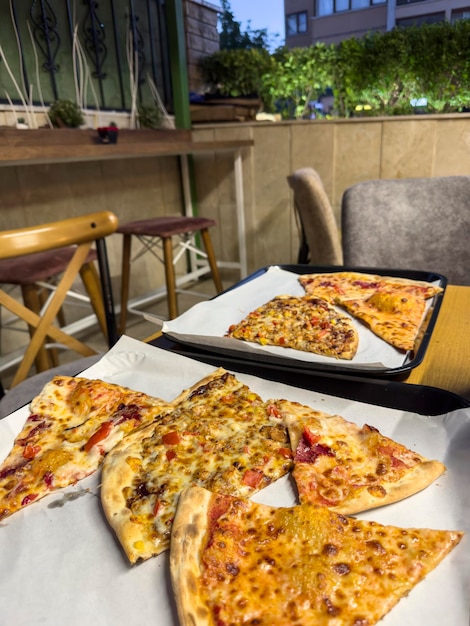 Foto corte em fatias deliciosas pizzas frescas com cogumelos e calabresa em um fundo de café vista superior
