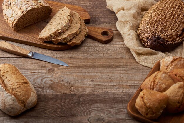 Foto corte fresco assado e pão integral e pães na mesa de madeira