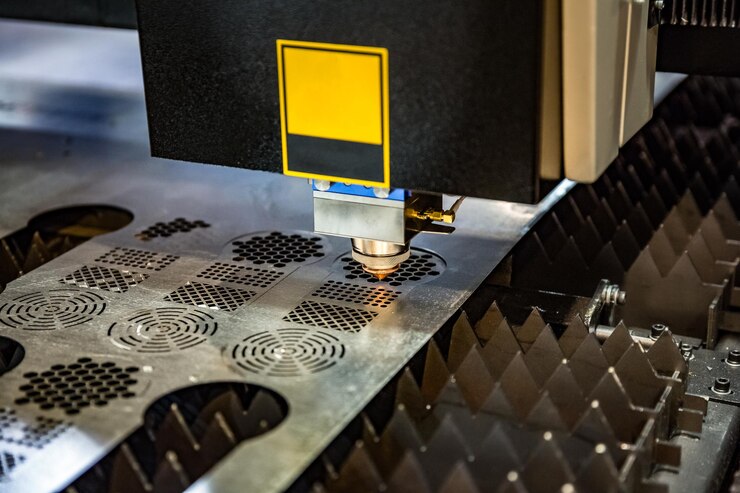 Foto corte láser cnc de metal, tecnología industrial moderna. pequeña profundidad de campo. advertencia: disparos auténticos en condiciones difíciles. un poco de grano y tal vez borrosa.