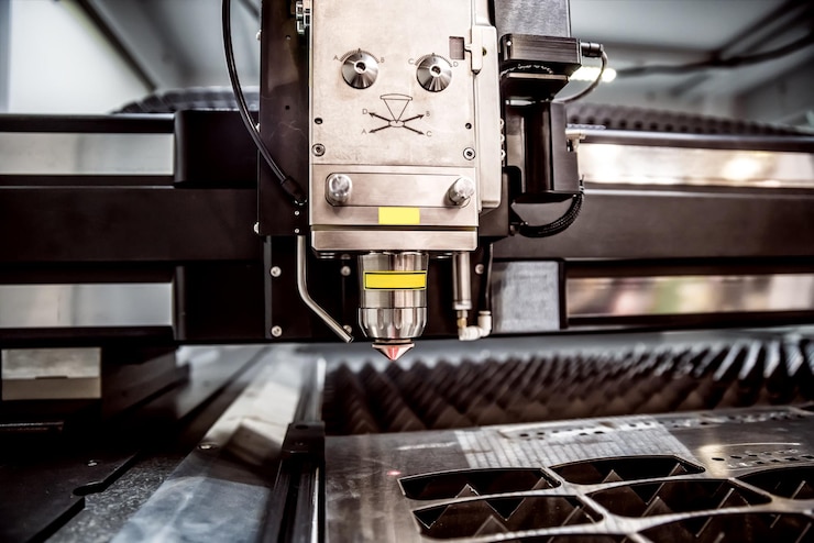 Foto corte láser cnc de metal, tecnología industrial moderna. pequeña profundidad de campo. advertencia: disparos auténticos en condiciones difíciles. un poco de grano y tal vez borrosa.
