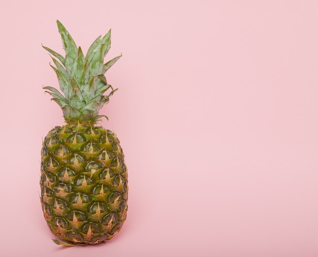 Corte metade do abacaxi suculento em uma parede rosa pastel. Conceito mínimo de verão.