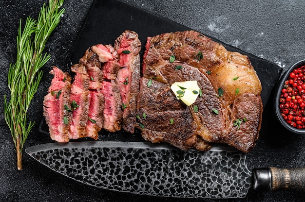 Corte o filé de carne bovina do rolo de olho de Chuck grelhado em uma placa de mármore