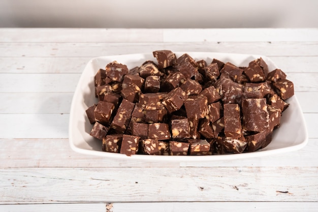 Corte o fudge de nozes de macadâmia em cubos pequenos.