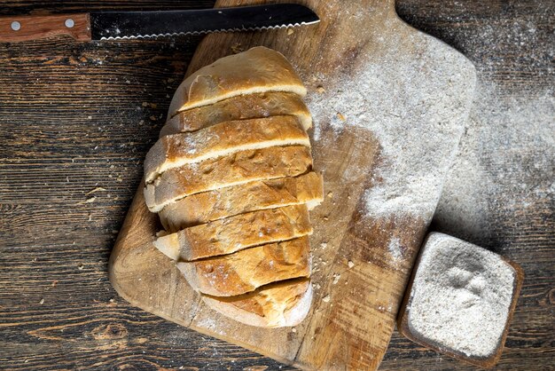 Corte o pão fresco em pedaços enquanto cozinha com pão o pão é cortado em pequenas fatias