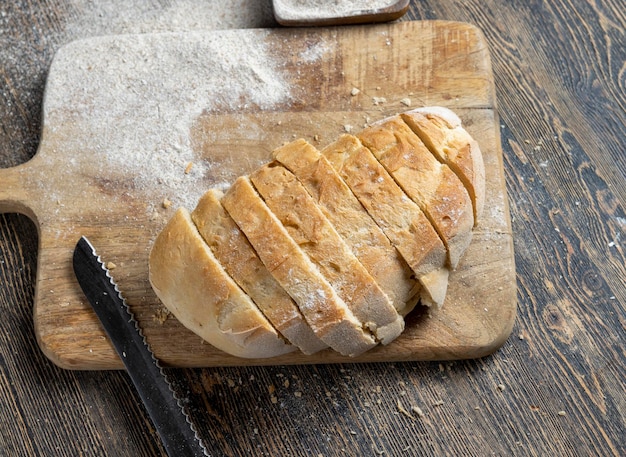 Corte o pão fresco em pedaços enquanto cozinha com pão