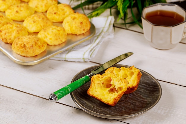 Corte el pan de queso brasileño en un plato con un cuchillo.