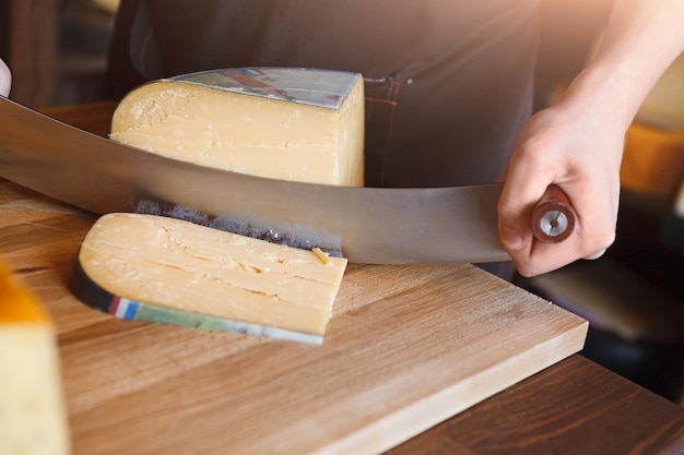 Corte parmesão, queijo duro, queijo pecorino na mercearia, closeup