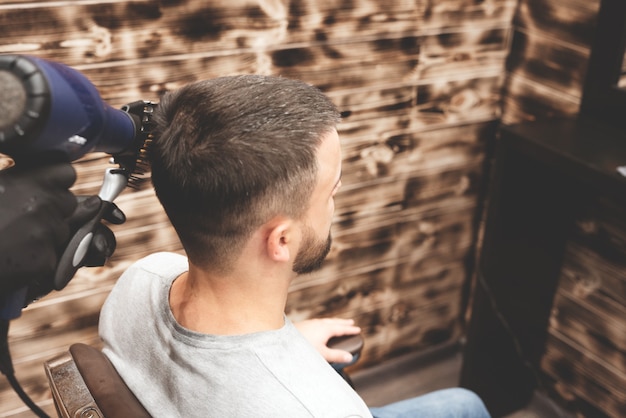 Corte de pelo en la barbería. Barber corta el pelo en la cabeza del cliente. El proceso de creación de peinados para hombres. Barbería. Enfoque selectivo.