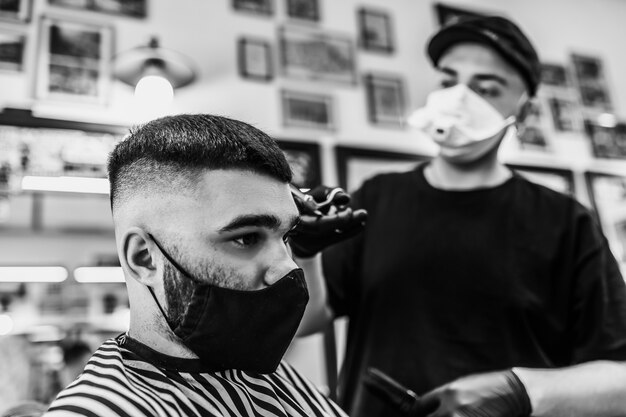 Corte de pelo en cuarentena. Corte de pelo en mascarillas del virus. Cuidado del cabello y la salud. Corte de pelo de hombre en