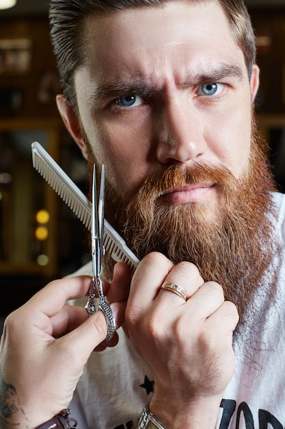 Corte de pelo moderno para hombres, peinado perfecto para hombres con cabello largo. Corte de pelo retro en la peluquería.