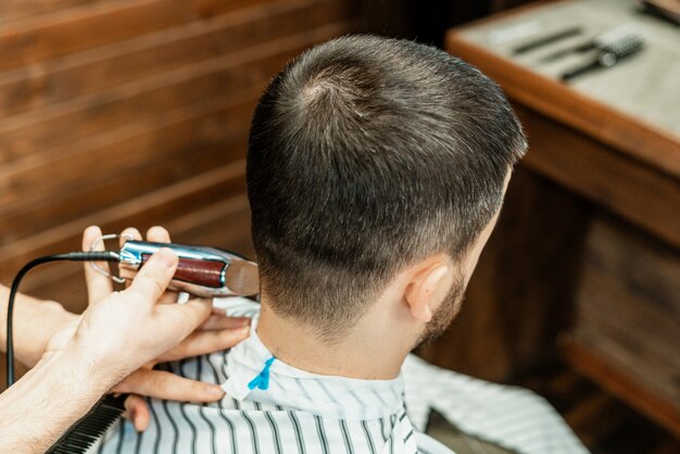 Corte de pelo en la peluquería. Peluquero corta el pelo en la cabeza del cliente