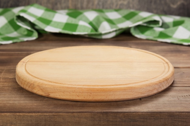 Foto corte de pizza y tablero de mantel de servilleta en la mesa de madera rústica, en el fondo de la tabla frontal