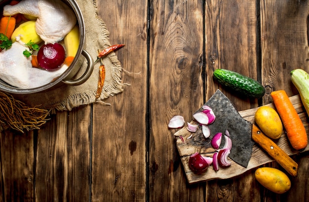 Corte de verduras al caldo de pollo. Sobre una mesa de madera.