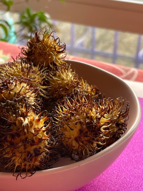 Corte vertical de frutas exóticas de rambutan em uma tigela sobre a mesa