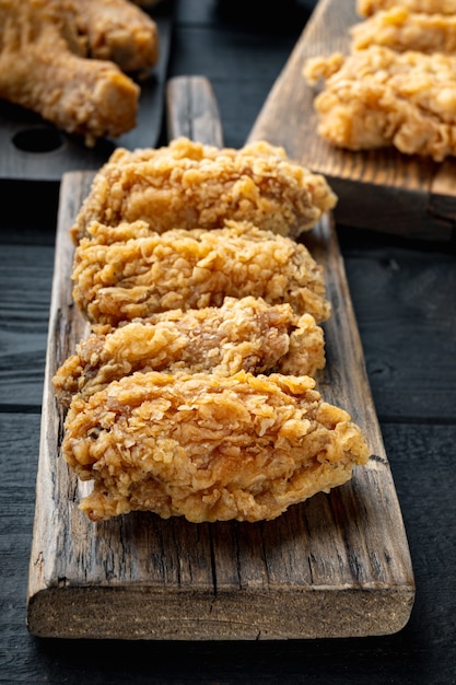 Cortes de alitas de pollo empanizadas en mesa de madera negra