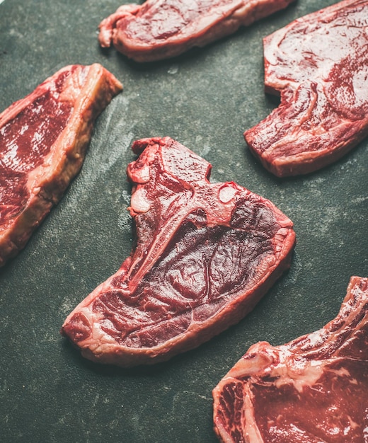 Cortes de bistec de carne de res cruda sin cocer sobre fondo negro