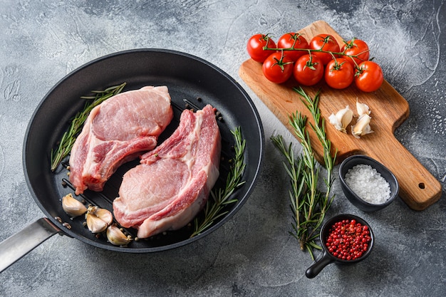 Cortes de carne cruda en una sartén, con hierbas y especias.