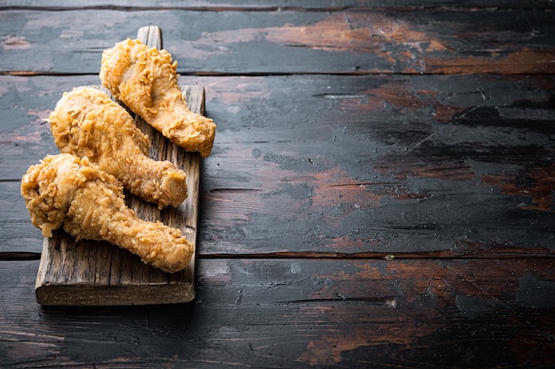 Cortes de pollo frito crujiente en la mesa de madera oscura.