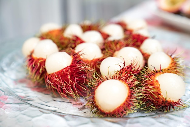 Foto la corteza de rambután se corta por la mitad en un plato de vidrio y está lista para comer