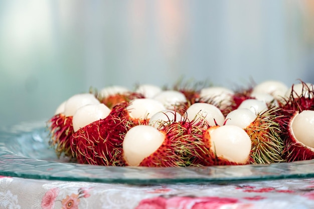 Foto la corteza de rambután se corta por la mitad en un plato de vidrio y está lista para comer