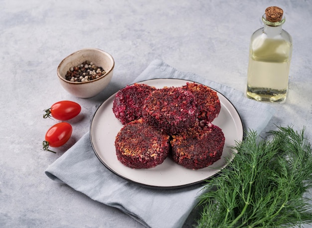 Cortillas vegetarianas fritas de remolacha en un plato sobre un fondo claro con hierbas frescas y tomates deliciosa comida de dieta vegana casera