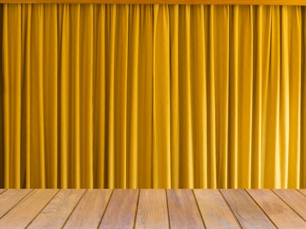 Foto cortina amarela com mesa de madeira.