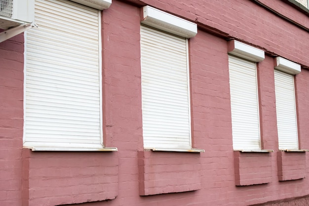 Cortinas nas janelas do prédio de tijolos vermelhos