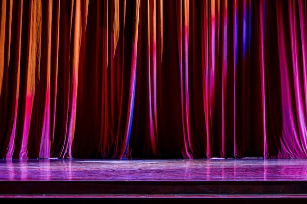 Foto cortinas rojas y el centro de atención en el teatro entre espectáculos.