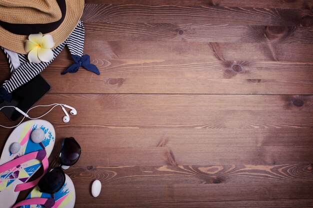 Cosas en una mesa de madera oscura fondo vacaciones piedras accesorios de playa traje de baño máscara Gafas de sol