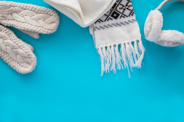 Foto cosas de punto acogedoras: una bufanda, guantes, cálidos auriculares en azul.