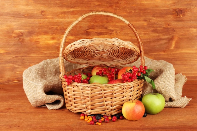 Cosecha de bayas y frutas en una cesta en primer plano de fondo de madera