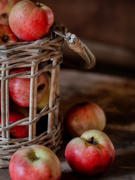 Foto cosecha fresca de manzanas de granja maduras y saludables en un frasco de vidrio, en una cesta.