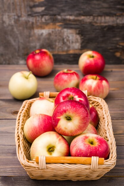 Cosecha fresca de manzanas. Tema de la naturaleza con manzanas rojas en una cesta en una mesa de madera