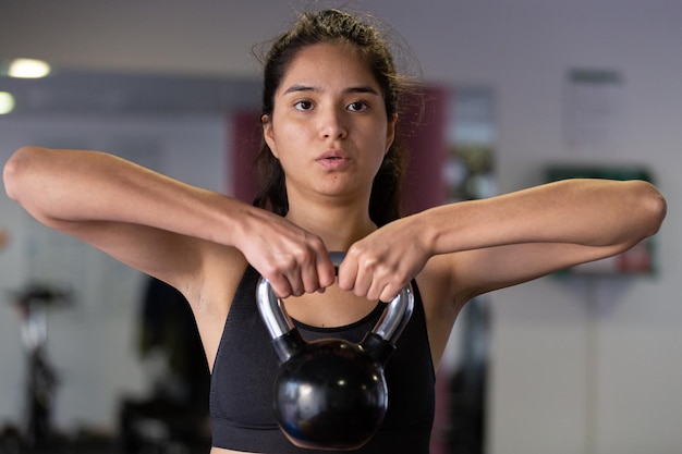 Cosecha joven levantando pesas en el gimnasio