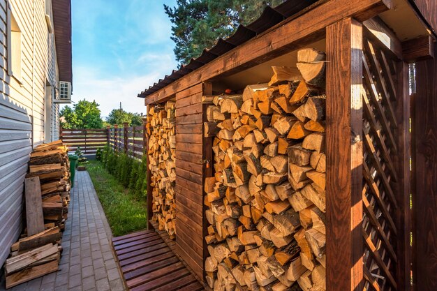 Cosecha de leña para el invierno cerca de la casa de vacaciones del pueblo de madera