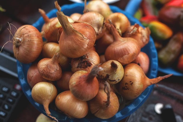 Foto cosecha otoñal de cebollas venta de productos de temporada en la feria callejera enfoque selectivo