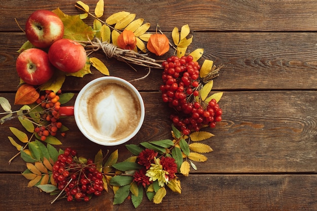 Cosecha de otoño. Pared de surtido de hojas y bayas de otoño. Concepto de bebida caliente