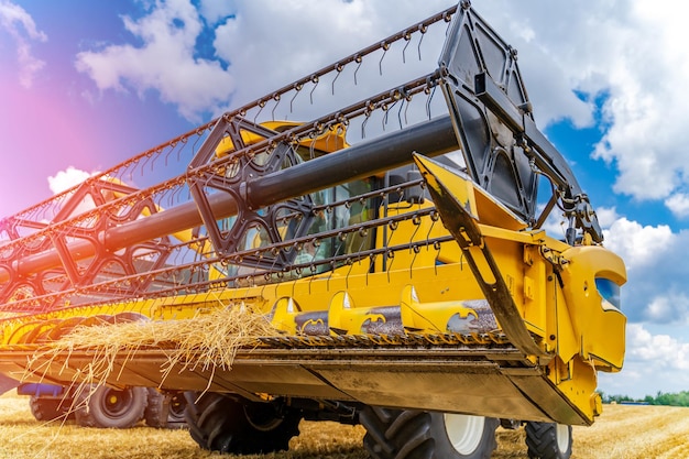 Foto cosechadora amarilla grande trabajando en el campo cosechadora grande levantando su cosechadora máquina agrícola