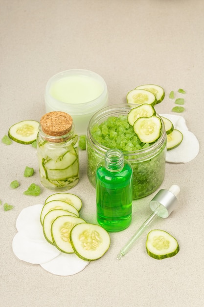 Cosmética casera con pepino. Mascarillas desintoxicantes de piel vegetal. Crema natural, sal marina, loción facial y agua tónica. Fondo de hormigón de piedra clara, cerrar